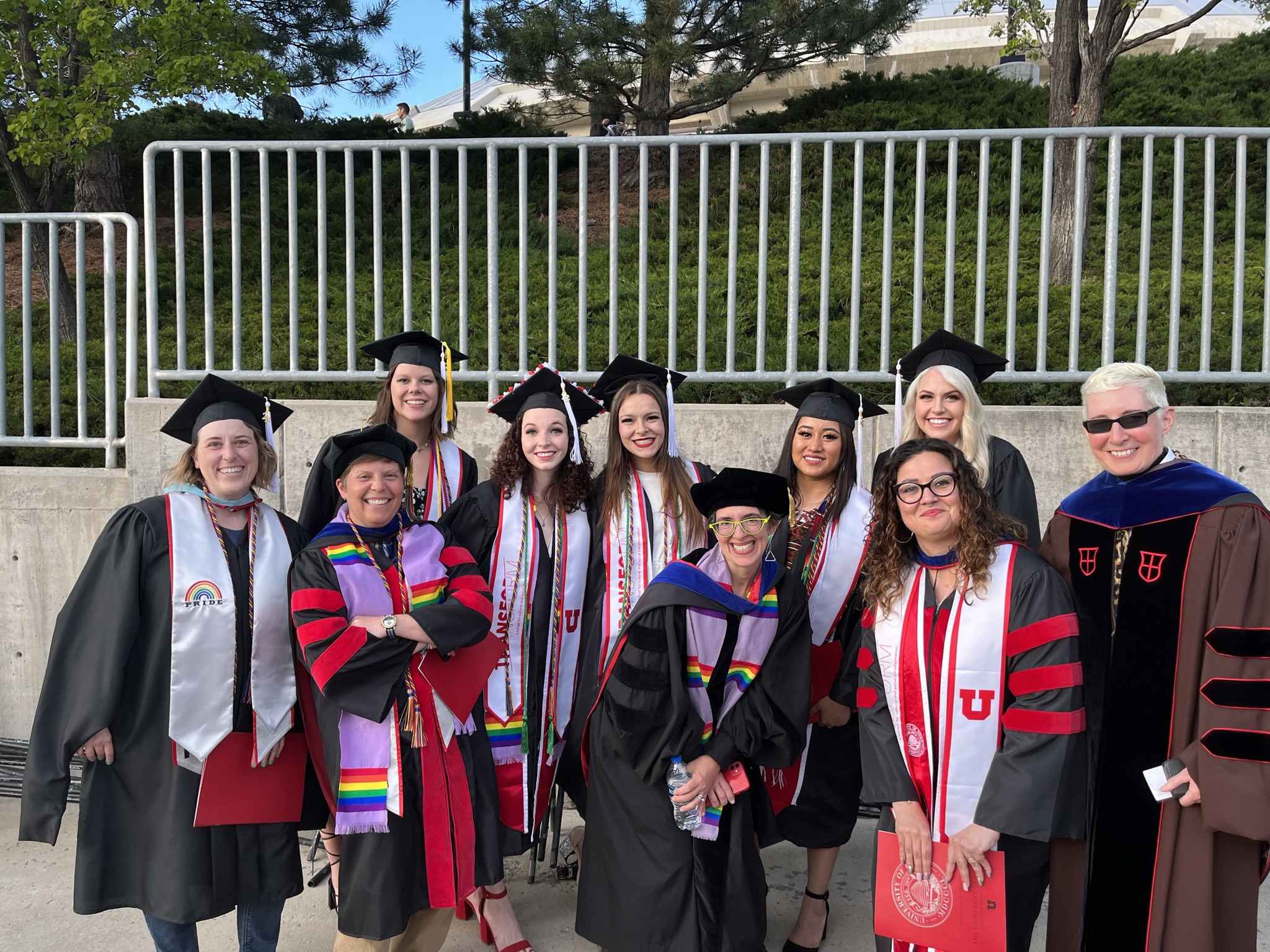 a group of Transform faculty, staff and students smile outside for Commencement